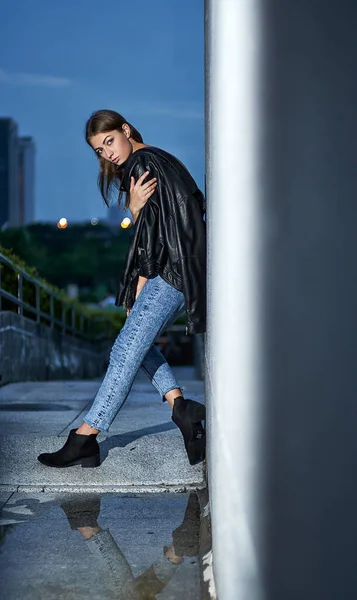 Bir deri ceket, kot pantolon, rahat tarzı Hong Kong sokakta duvarın yanında poz büyük esmer saçlı genç güzel seksi kadın. Moda sokak vogue modeli açık fotoğraf çekim