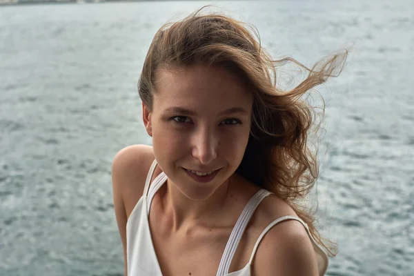 Kahverengi saçlı, harika gözleri ve okyanus plaj Hong Kong Metropolis'te gülümsemek güzel genç kız. Moda model fotoğraf portre