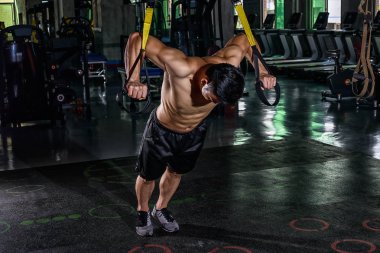 Trx ile spor salonunda eğitim genç atletik seksi Çinli. Spor fitness fotoğraf