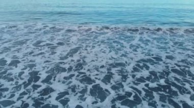 Ada Bali, harika renkli görüntüsü, video 4 k uçaktan aşağı kamera önceden çekim inanılmaz masmavi su, harika mavi bulutlu gökyüzü, siyah kum ve köpük ile bir güzel okyanus plaj havadan görüntüleri dalgalar