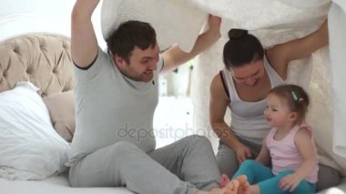 Mutlu anne ve genç kızı yatakta oynarken