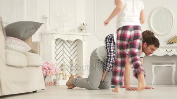 Fiatal apa, játszik a lánya és a fia a nappali padlón — Stock videók
