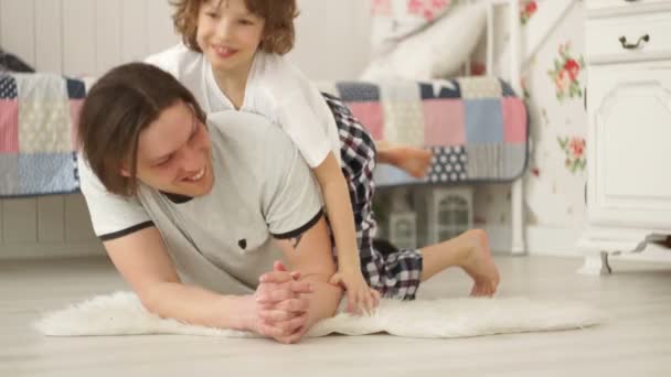 Fils et son jeune père jouent sur le sol dans la chambre . — Video