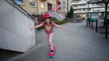 Kız Kızıl bir kaykay sürmek