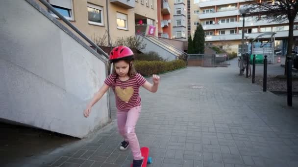 女の子は、スケート ボード クリムゾンの乗り物 — ストック動画