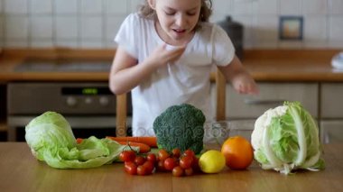 Sebze yemek başında mavi bir yay ile şirin kız.