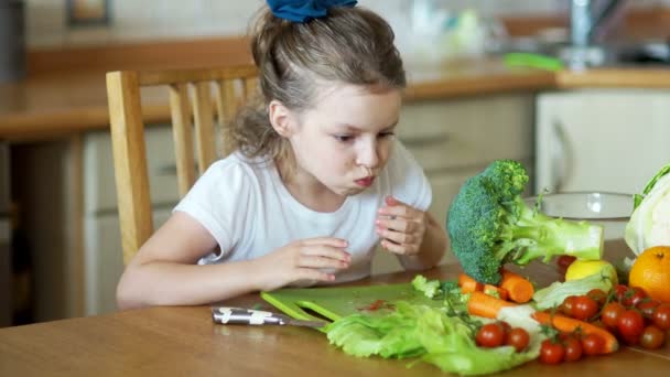 Roztomilá dívka dychtivě jí zelenina. — Stock video