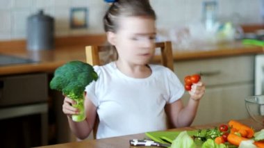 Küçük kız hevesle sebze yiyor.