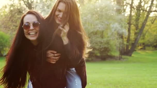 Portret van jonge langharige brunette op een achtergrond van groen gras en lentetuin. — Stockvideo