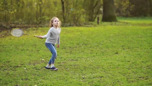 Девушка играет в бадминтон в парке. — стоковое видео