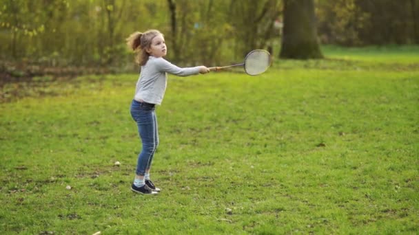 Lockiges hübsches Mädchen spielt Badminton im Park. — Stockvideo