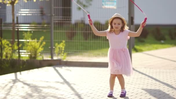 Dívka skákání přes švihadlo na hřišti. — Stock video