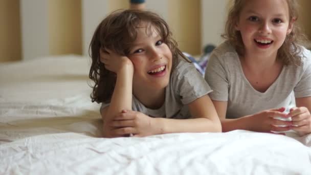 Irmão e irmã relaxando juntos na cama . — Vídeo de Stock