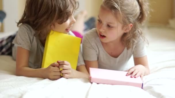 Hermano y hermana divirtiéndose con libros en el dormitorio . — Vídeos de Stock