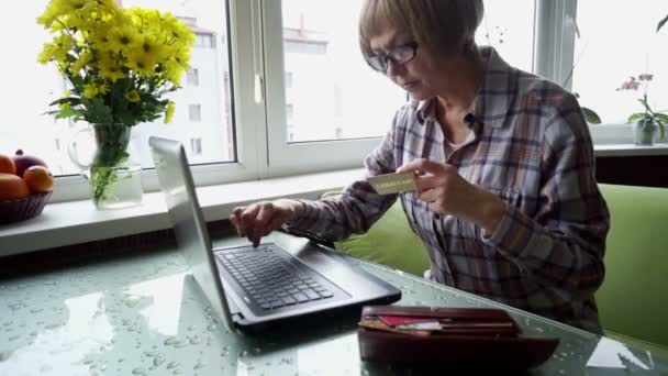 La donna anziana malata di artrite reumatoide che utilizza internet banking in casa . — Video Stock