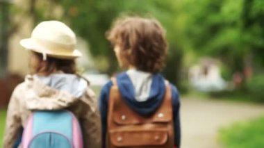 Üç çocuk - kız ve iki erkek park açık havada yürüyüş. Kardeş kardeşi okula geri ile