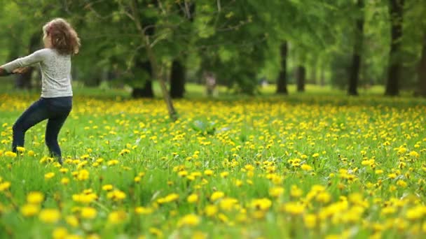 Prachtige kinderen zijn cirkelen in een glade van paardebloemen. Een jongen en een meisje zijn gelukkig lachend. Weekend buiten de stad, rust, schoolvakanties, childrens vriendschap — Stockvideo