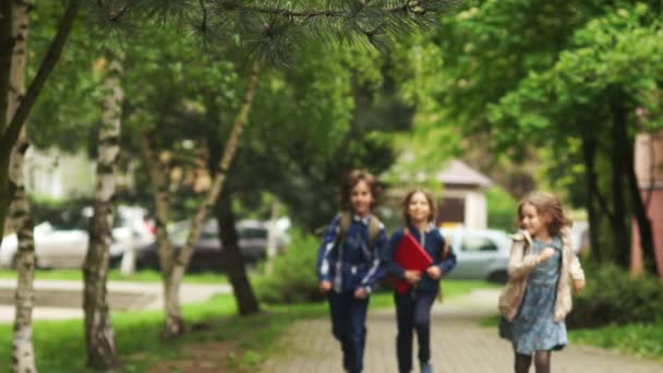 Δύο αγόρια και ένα κορίτσι έρχονται πίσω από το σχολείο. Παίζουν catch-up. Η ευθυμία τους μαθητές. Φιλία μεταξύ αγοριών και κοριτσιών. — Αρχείο Βίντεο