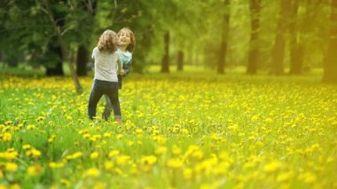 Sevimli kız ve erkek 9-10 yaşında kıvırcık saçlı dandelions glade parkta iplik