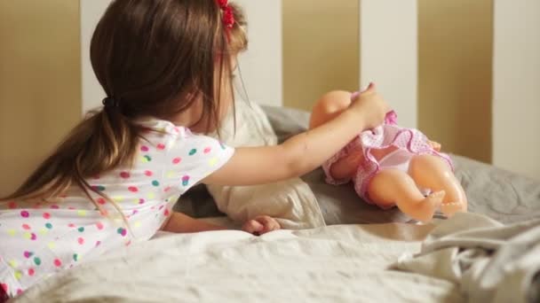 Chica jugando con la muñeca. La puso a dormir y le dio un chupete. Feliz infancia. Juegos de niños. Madres hijas — Vídeo de stock