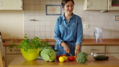 Genç bir esmer bir salata için kesme sebze var. Havuç ve dansları eğlenceli çalışır. Biz kendimizi pişirin. Ev yemekleri
