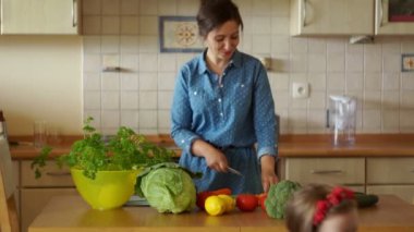 Anne ve küçük kızları birlikte mutfakta yemek. Aile yemeği. Anneler asistanı. Mutlu bir aile