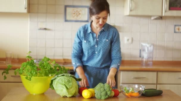 Una giovane donna sta preparando una zuppa danzante tra un fornello e un tavolo. Che buon umore. Cucina casalinga. Vegetarismo. Note di alimentazione — Video Stock