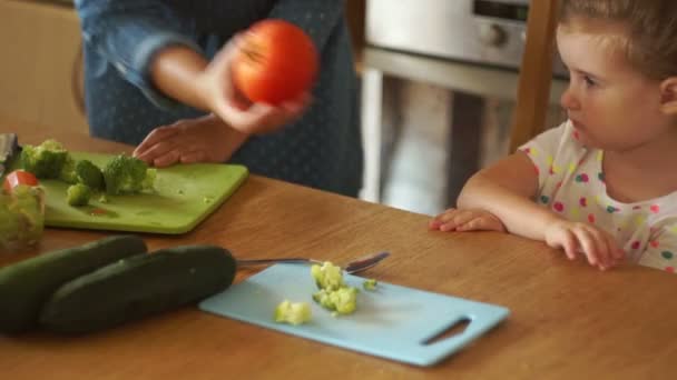 Mamá le da a su hija un tomate, Lemon. La chica aleja las verduras. Comida para bebés. Estilo de vida saludable. Caprichos infantiles . — Vídeo de stock