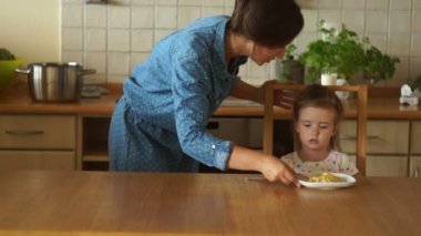 Anne ve kızı mutfakta. Anne kız süt verir. İyi bir iştah. Sağlıklı beslenme