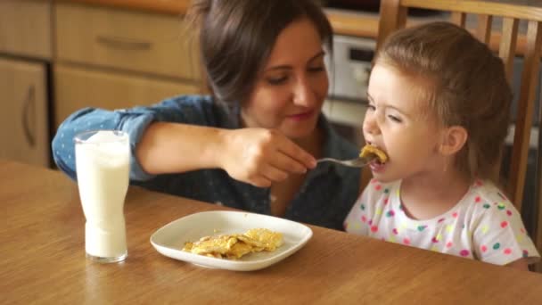 Mamma matar sin lilla dotter. Flickan öppnar lydigt munnen. Äggröra, hälsosam frukost, barnmat. — Stockvideo