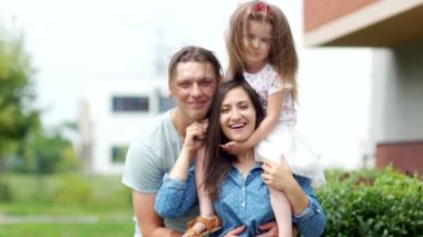 Genç bir aile portresi. Anne, baba ve küçük kızı. Neşeli gülmek.