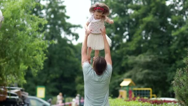 Papá y su hija se divierten en el parque. El padre vomita a la chica. Fin de semana familiar. Padres amor . — Vídeos de Stock