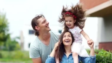 Küçük kızı olan mutlu anne. Kız onu anneler omuz oturuyor. Uzun saçları güzel rüzgarda çırpınan.