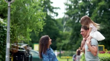 Aile öper. Anne, baba ve küçük kızı Şehir Parkı yürüyüş.