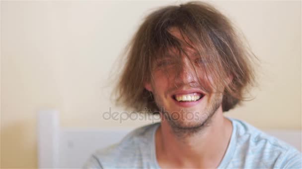 Porträtt av en ung attraktiv man. Han skrattar och viftar sitt huvud. Hår stänger ansiktet — Stockvideo