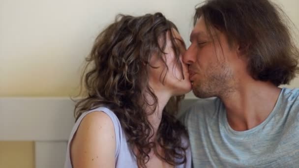 Joven pareja amorosa abrazándose y besándose en la cama — Vídeo de stock