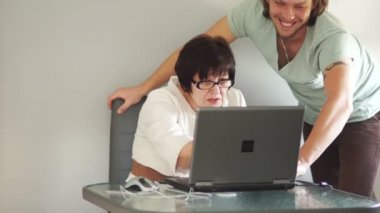 Genç bir adam bir emekli Internet'te faturaları ödemek yardımcı olur. Bilgisayar bilgisi, Internet teknolojileri