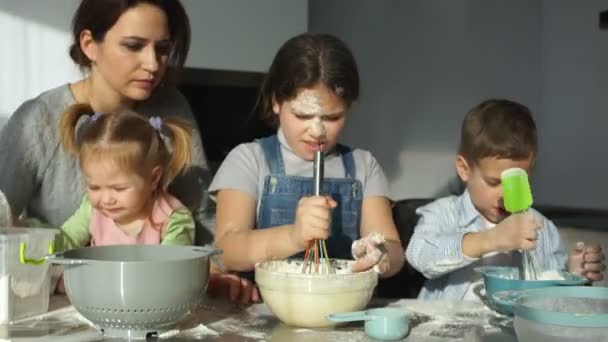 Una madre joven con tres hijos prepara masa para albóndigas y ravioles. Cocina eslava, platos rusos — Vídeo de stock