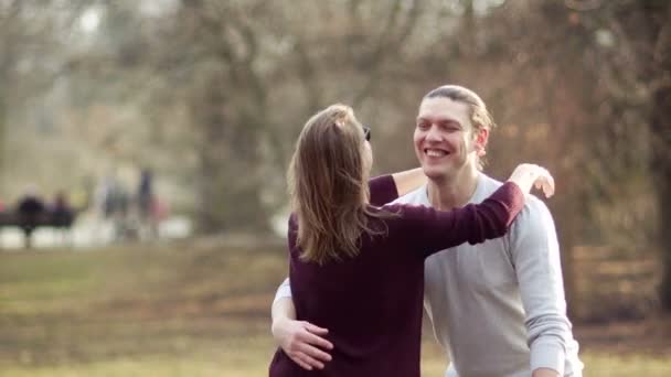 Una joven pareja encantadora felizmente se conoce. Amistad entre un hombre y una mujer. La abraza y se vuelve — Vídeo de stock