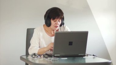 Orta yaşlı bir kadın ailesini Skype üzerinden iletişim kurar. Video bağlantısı. Onun elini sallayarak elveda diyor, konuşmayı sona erdirir