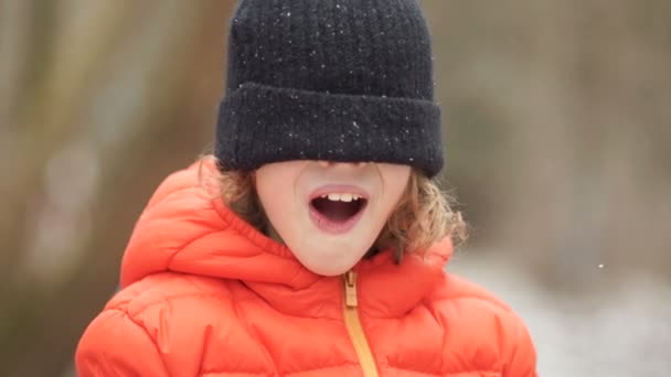 Portret van een jongen in een winter gebreide cap. Zijn ogen zijn gesloten met een hoed, schreeuwt hij — Stockvideo