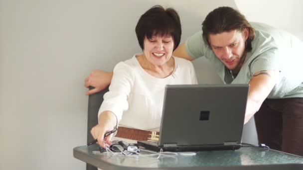 The colleagues are discussing an important working project. A woman dresses glasses and looks closely at the monitor — Stock Video