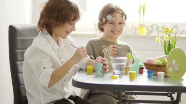 Bir erkek ve bir kız Paskalya kutlamaları için hazırlanıyorlar. Onlar Paskalya yumurtaları ve tavşan rakamlar renk. İyi eğlenceler gülüyor