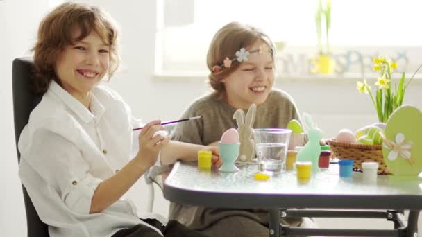 Inför påsk. Bror och syster dekorera påskägg. Barn skratta glatt. Slow Motion — Stockvideo