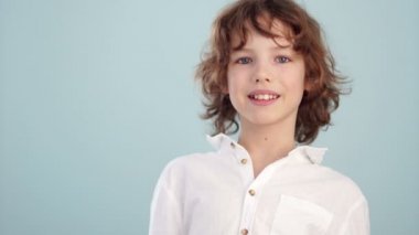 Genç Beyaz forması. Güzel beyaz gülümseyen çocuk, açık mavi renkli. Çocukluk, moda ve tasarım reklam kavramı