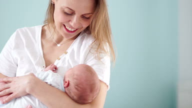 Anne yavaşça yeni doğmuş bir bebek beşik. Anne sevgi ve bakım. Yatıştırır ve bebeğin kafasına vuruş. Anneler günü
