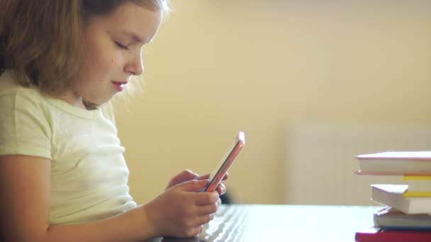 Uma menina está jogando jogos em um telefone celular. Vício em Internet. Ele sorri astuciosamente. Usando telefone celular — Vídeo de Stock