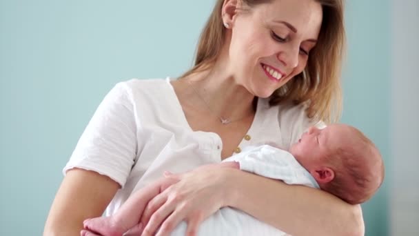 Un bebé recién nacido está en los brazos de las madres. Mamá y su hijo. Día de las Madres. Golpea suavemente la cabeza de su hijo. Moción lenta — Vídeos de Stock