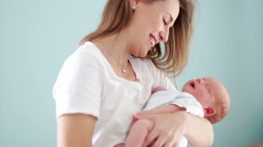 Bir iki-hafta-yaşlı çocuk anneler kollarda yalan rüyada, gülümsüyor. Annelik sevinci. Ailesinin yeni üyesi. Anneler günü