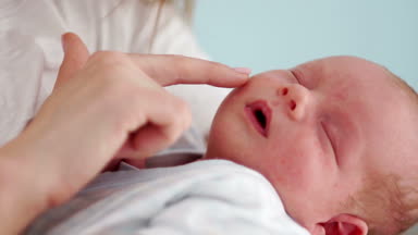 Yeni doğmuş bir bebek portre kadar kapatın. Bir iki haftalık bebek annesinin kollarında uyur. Anneler günü. Aile kavramı. Çocuk günü. Ağır çekim